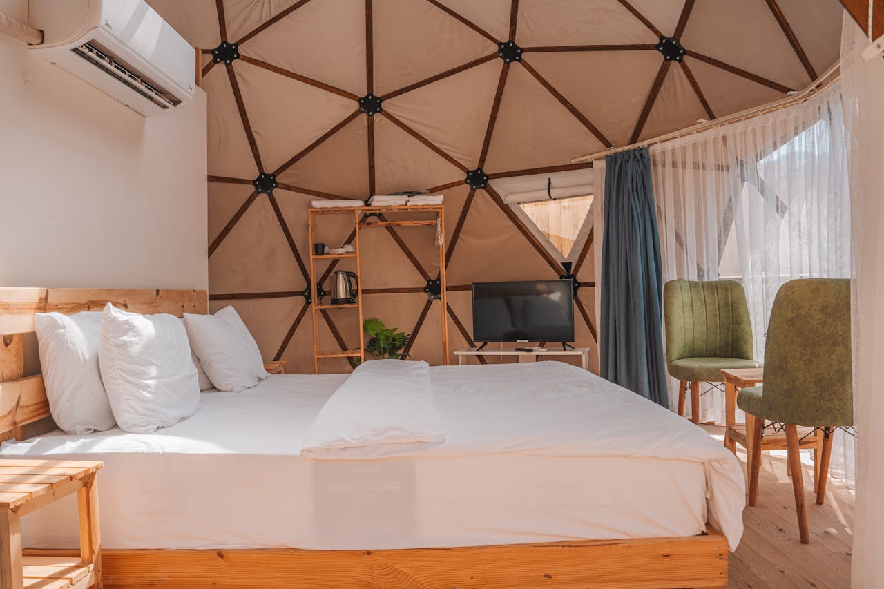 Modern dome accommodation interior featuring a bed, air conditioning, and seating area in Kemer, Türkiye.